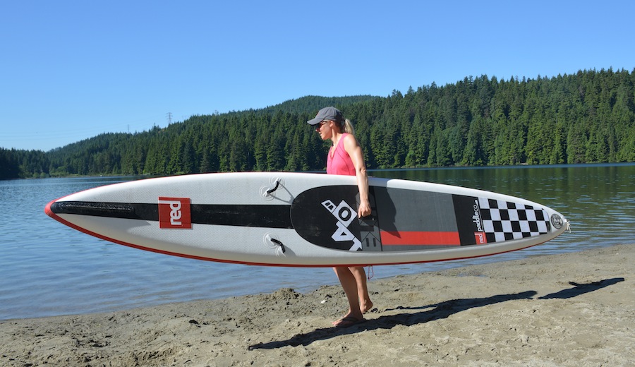 carrying the Red 14' Elite Race inflatable racing SUP